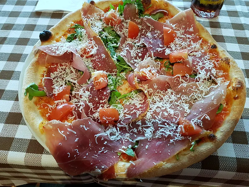 Pizza mit Prosciutto Crudo, Rucola und Parmesan